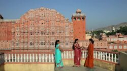 Three women in colorful saris visit on a balcony near Palace of the Winds in Jaipur, India. Stock Footage