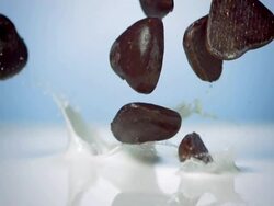 HD Super Slow-Mo: Chocolate Hearts Splashing Into Milk Stock Footage