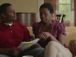 Man reading magazine on sofa, man joins him with coffee mugs, they relax, look out window and talk. Stock Footage