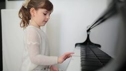 Cute girl learning to play piano Stock Footage
