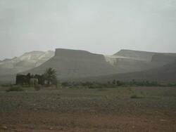 Wide shot of an old, rustic building set in an unforgiving landscape. Stock Footage