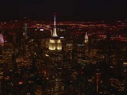 Aerial -At night, flying north over Manhattan with a slow ZI to include the Empire State building passing in front of the Chrysler building. Stock Footage