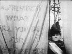 B/W 1917 suffragist standing by banner + looking at camera / newsreel Stock Footage