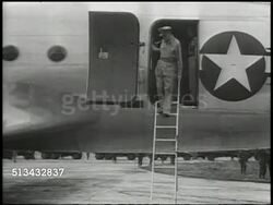 1945: JAPANESE OCCUPATION:  WS Douglas C-54 Skymaster airplane landing on Ozuki Air Field (unconfirmed). VS General of the Army Douglas MacArthur (1880-1964) deplaning, greeting officers on air field. WWII, Pacific Front, surrender, World War II Instructional Video