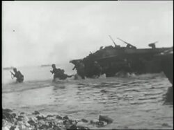 Soldiers crowd into a landing craft on D-Day and land on Normandy beaches as the wounded are carried by their fellow soldiers. News Clip