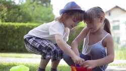 Little boy and toddler girl playing in the garden Stock Footage
