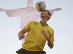 MS A young man wearing a Brazil t-shirt practices football skills in front of Cristo Redentor on Corcovado / Rio de Janeiro, Brazil Stock Footage