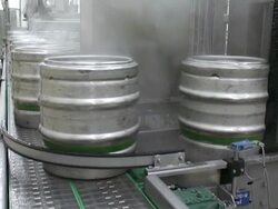 MS Shot of Aluminum beer barrels moving on conveyor at beer production at brewery, Bitburger Pils Stock Footage