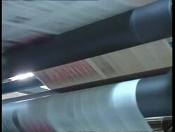 MCU low angle, Newspaper print run moving through conveyor belts in printing factory Stock Footage