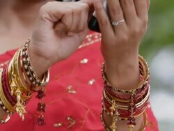 CU TU Young woman in sari text messaging on mobile phone in park / Singapore  Stock Footage