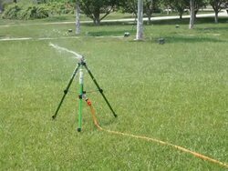springkler watering park lawn at daytime Stock Footage