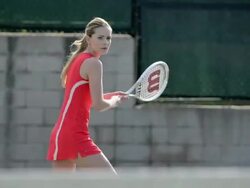 CU of a female tennis player as she hits the tennis ball backhand and water sprays. Stock Footage