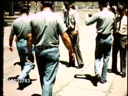 1967: COLORADO STATE PENITENTIARY: ZI to MS Plaque sign, 'Entrance Colorado State Penitentiary' on stone wall. VS Prison guard, corrections officer, walking on barrier wall, guards in CSP prison yard patting down inmates. CO, jail Instructional Video