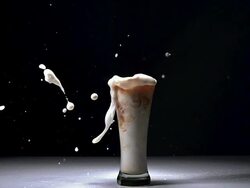 MS SLO MO Glass of Beer splashing against black background / Vieux Pont, Normandy, France Stock Footage