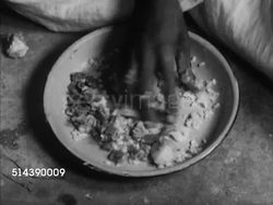 1949: INDIA CASTE SYSTEM: OUTCASTS / UNTOUCHABLES: WS One room hut home w/ straw roof, VS Family eating meal inside, MS Father, TD MS Male fingers picking up food, VS Husband, wife, children eating, girl child has eye problem, one enlarged, static. Instructional Video