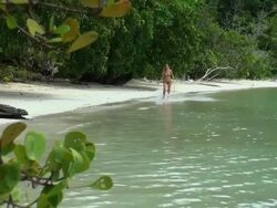 Happy blond girl jumping and walking on the shoreline Stock Footage