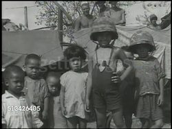 1944: BATTLE OF SAIPAN:  VS Indigenous Chamorro people (aka Chamoru) walking w/ U.S. 2nd Marine Division soldier, child being carried, children standing together in refugee camp, children & other natives getting water & food, attending funeral. WWII Instructional Video