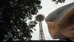 The Space Needle with the Experience Music Project museum and trees,clouds with sun behind it. Stock Footage