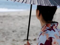 Japanese woman with a parasol enjoying sea Stock Footage