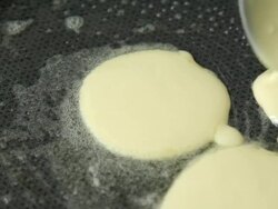 Pouring pancake batter into the pan Stock Footage