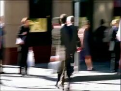 MS business man on rollerblades weaves in and out of traffic and pedestrians Stock Footage