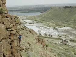 Man climbs a steep rock  face with the city of Denver in the background Stock Footage
