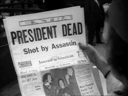 B/W 1963 close up over-the-shoulder newspaper headlines "President Dead. Shot by Assassin" / Kennedy's assassination Stock Footage
