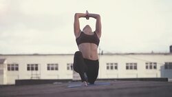 Young woman doing yoga outdoors on a rooftop at sunset Stock Footage
