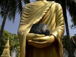 MS TU Buddha figure with alms bowl under palm tree  AUDIO / Luang Prabang, Luang Prabang, Laos Stock Footage