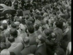 May 6, 1961 FILM MONTAGE MS Police holding crowds back/ John F. Kennedy and Harold Macmillan walking toward Jacqueline Kennedy/ WS Motorcade/ Crowd/ at Buckingham Palace/ MS Police pushing crowd back as motorcade arrives/ London, England/ AUDIO Stock Footage