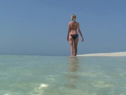 Solitary woman walking on the ocean shore Stock Footage