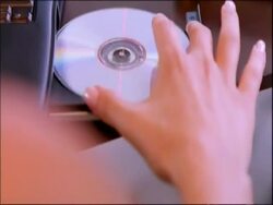 CU hand inserting CD into disc drive Stock Footage