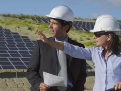 MS ZI Businessman and female engineer discussing plans and shaking hands in front of photovoltaic (solar) plant / Malaga, Spain Stock Footage