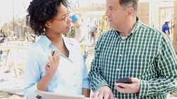 Building construction foreman meets with charity executive about charity house Stock Footage