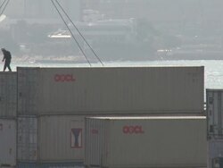 Dock worker stands dangerously on shipping containers as crane lifts another container above him, Hong Kong Stock Footage