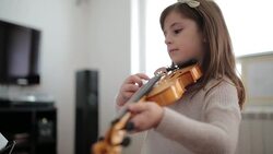 Young cute girl playing violin at home Stock Footage