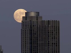 Shot of the moon rising over a building in the Manhattan Skyline in New York City. Stock Footage