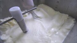 A chef whisks a cream mixture in a vat. Stock Footage