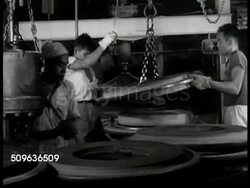 1940: EAST INDIES RESOURCES: People pushing three large carts, factory buildings BG. Worker pulling rubber tire out of mold w/ hook, ropes. Indonesian workers making rubber tires, molds. Indonesian people walking on dirt road. Male scoring rubber tree Instructional Video