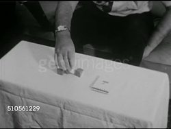 1965: BRAIN TESTING: SPLIT BRAIN PATIENT: TD MS Male arms w/ geometric pattern painted blocks on table FG, notepad w/ example of pattern to match, arranging pattern w/ LEFT hand, RIGHT hand can't perform, both hands can't work together. Instructional Video