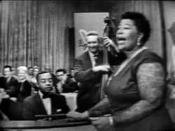 B/W 1955 Ella Fitzgerald singing with band / audience in background / The Larry Finley Show Stock Footage