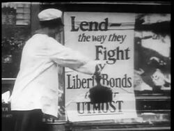 B/W 1910s woman plastering poster advertising Liberty Bonds / World War I / newsreel Stock Footage