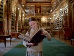 Long shot girl opening and reading book in Philosophical Hall library at Strahov Monastery / Prague Stock Footage