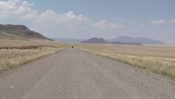 A jeep speeds along a road in the Namib Desert. Stock Footage