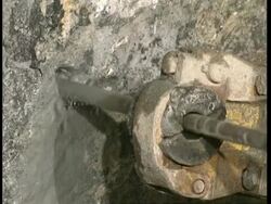 CU Water-cooled drill drilling into rock wall Stock Footage