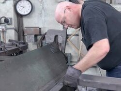 metal worker clamps shaped piece of metal into vintage bending press and pulls large lever to bend metal into exact right angle / Redlands, California, USA Stock Footage