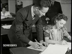 1934: CARDENAS POSTERS: CU 'Constitucion Federal El Subsuelo' (subsoil). WS Building. VS American workers going over paper work at desk. EXT MS Man putting up illustrated Cardenas poster. WS Poster being put up at car wash. WS Poster on bridge. Mexico Instructional Video