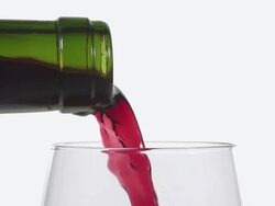 CU SLO MO Shot of Red wine being pour into glass against white background / Calvados, Normandy, France Stock Footage