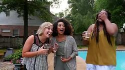 MS Smiling women sharing wine during backyard party on summer evening Stock Footage