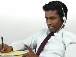 Charismatic Guy On Headset, Taking Notes Stock Footage